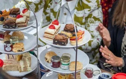 Cakes and sandwiches served on tiered stands during a seasonal tea bus experience